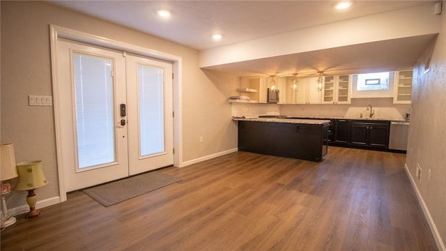 kitchen with appliances with stainless steel finishes, sink, white cabinets, dark wood-type flooring, and french doors