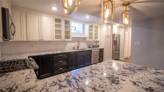 kitchen featuring white cabinetry, appliances with stainless steel finishes, sink, and hanging light fixtures