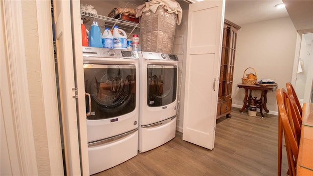 clothes washing area featuring wood-type flooring and separate washer and dryer