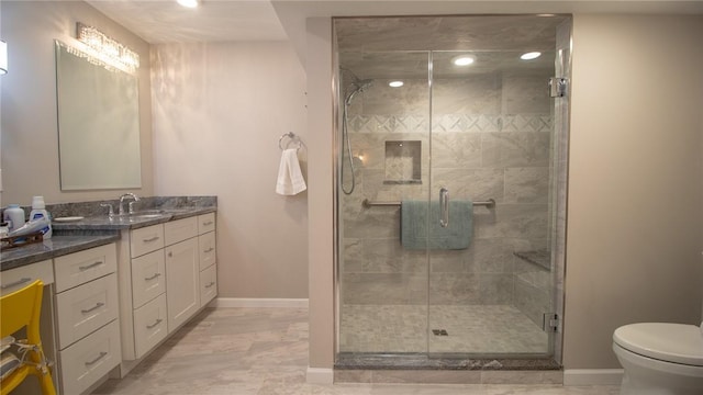 bathroom featuring vanity, a shower with door, and toilet