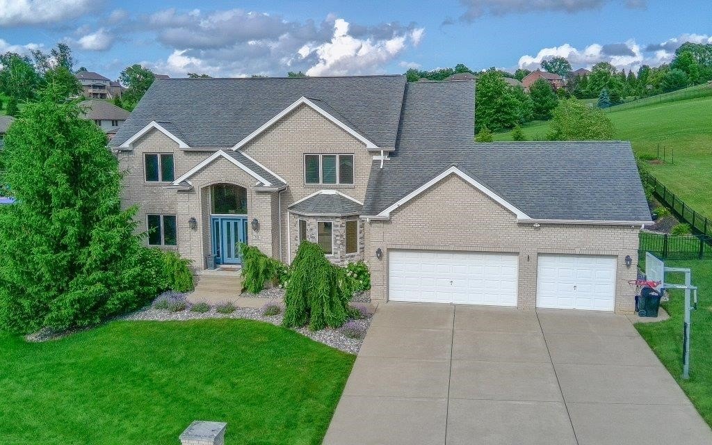 713 Bradgate Dr, North Huntingdon, PA 15642 - view of front facade with brick siding, an attached garage, driveway, and a shingled roof