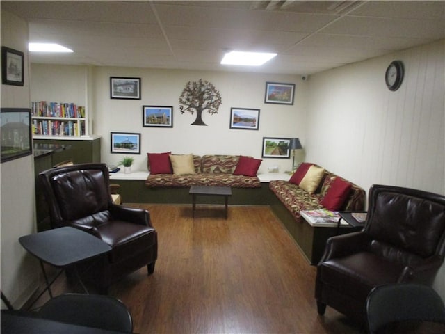 living room featuring a paneled ceiling and wood-type flooring