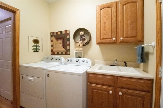 laundry area featuring cabinets, sink, and washer and dryer