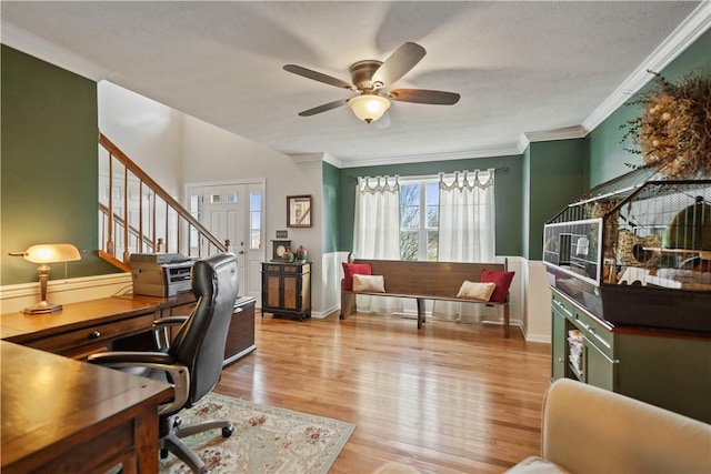 office space with crown molding, ceiling fan, and light wood-type flooring