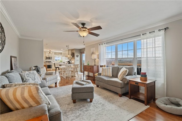 living room featuring crown molding, ceiling fan, and hardwood / wood-style floors