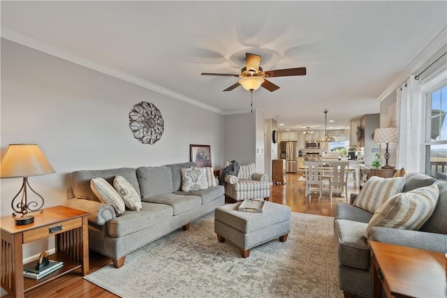 living room featuring crown molding, ceiling fan, and wood-type flooring