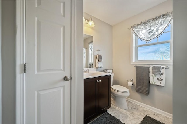 bathroom featuring vanity, a wealth of natural light, tile patterned floors, and toilet