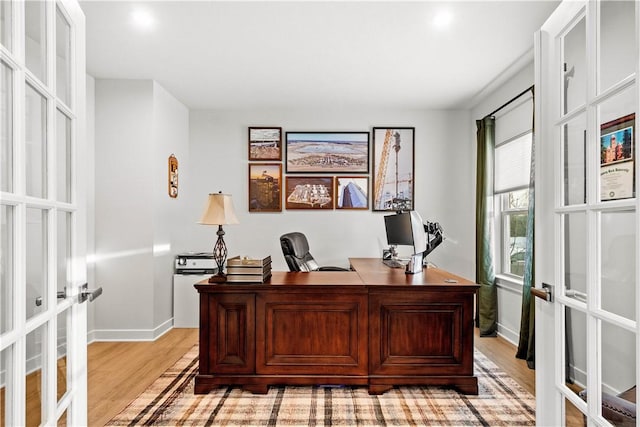 office space with light wood finished floors, french doors, and baseboards