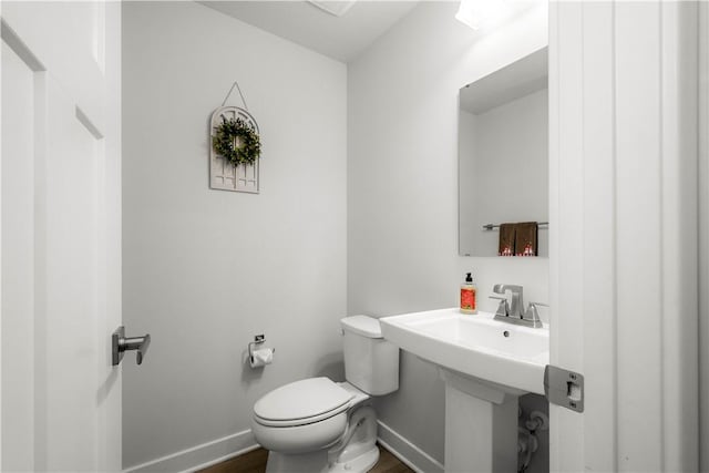 bathroom featuring wood finished floors, toilet, and baseboards