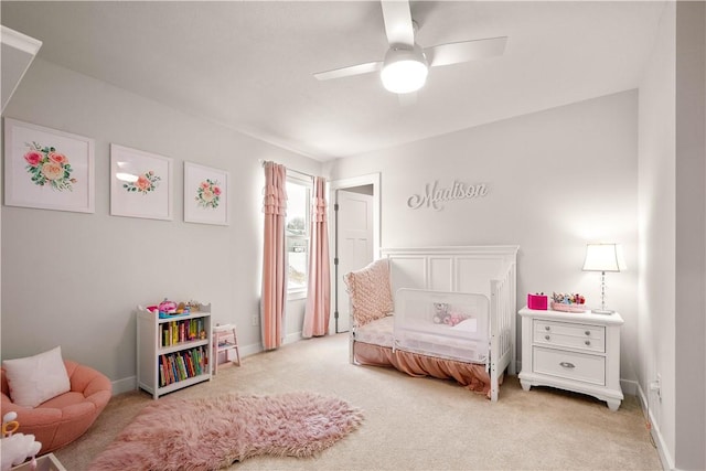 bedroom featuring light colored carpet, ceiling fan, and baseboards