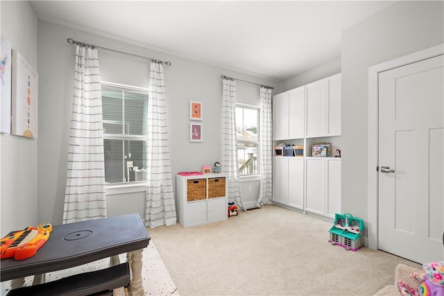 recreation room featuring light colored carpet