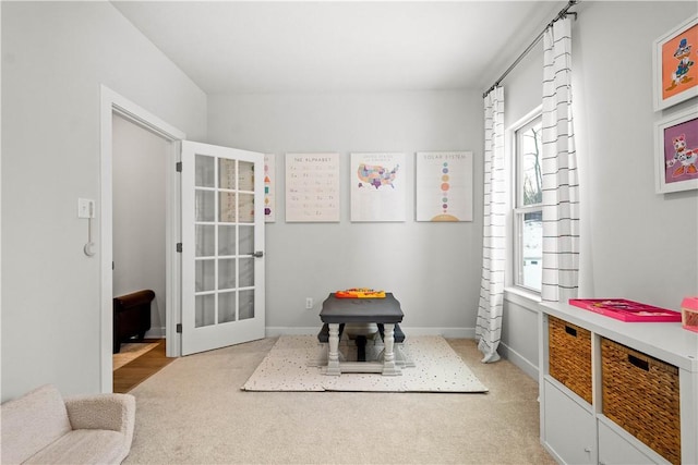 game room featuring light carpet and baseboards