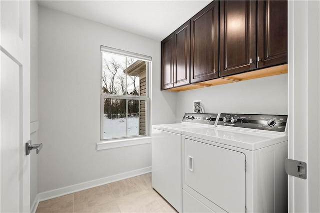 clothes washing area with cabinet space, baseboards, and washer and clothes dryer