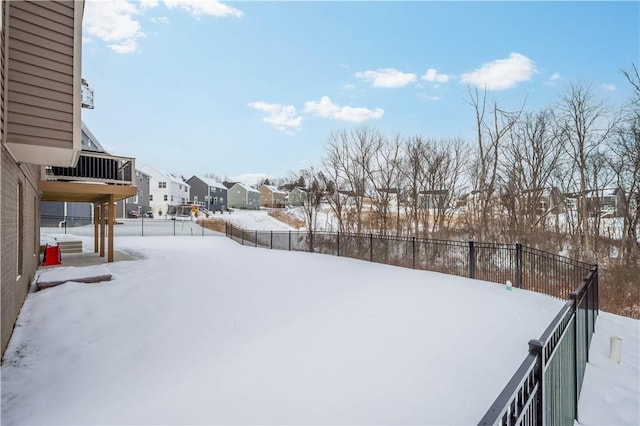 yard covered in snow featuring a residential view and a fenced backyard