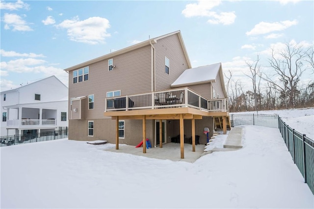 snow covered property with fence and a wooden deck