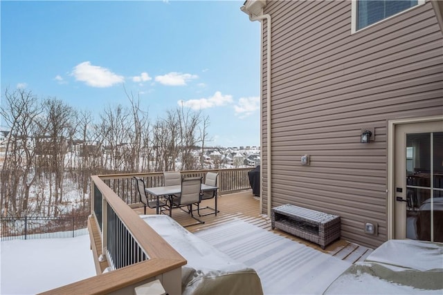 snow covered deck featuring outdoor dining area