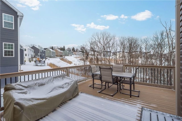 snow covered deck with outdoor dining area and a residential view