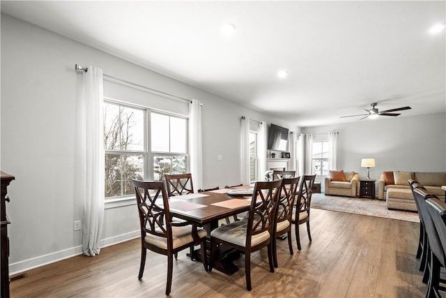 dining area featuring a ceiling fan, wood finished floors, visible vents, and baseboards