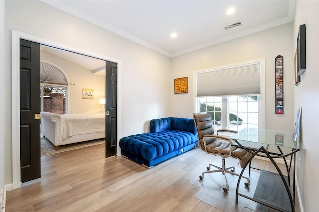 sitting room with crown molding and light wood-type flooring