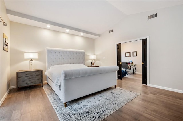 bedroom with vaulted ceiling and hardwood / wood-style floors