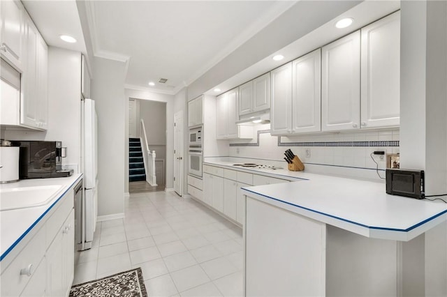 kitchen with white appliances, ornamental molding, decorative backsplash, and white cabinets