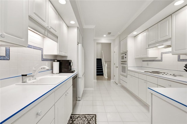 kitchen with white cabinetry, sink, and white appliances