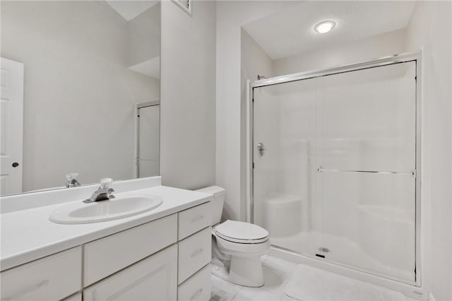 bathroom featuring vanity, a shower with door, and toilet