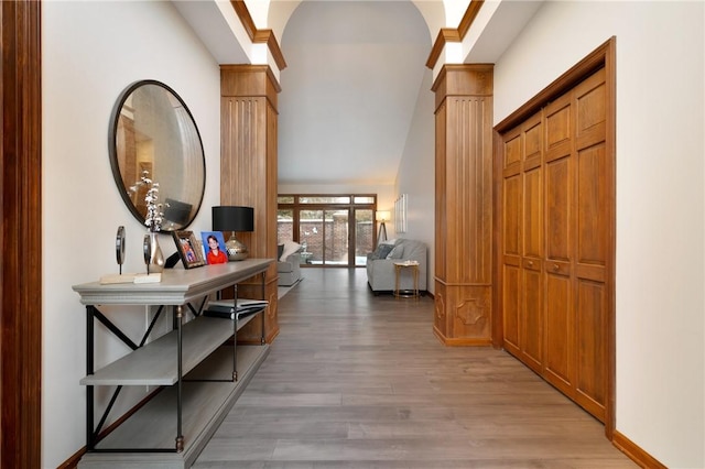 hallway featuring light hardwood / wood-style floors and decorative columns