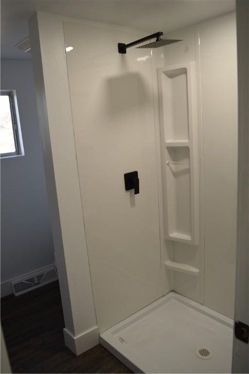 bathroom featuring wood-type flooring and walk in shower