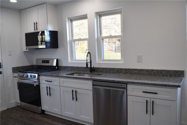 kitchen featuring dark hardwood / wood-style flooring, sink, stainless steel appliances, and white cabinets