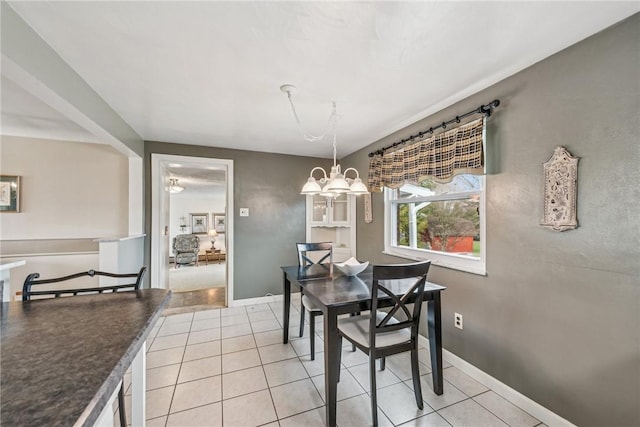 tiled dining area featuring a chandelier