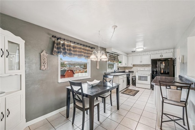 dining space with an inviting chandelier, light tile patterned floors, and sink