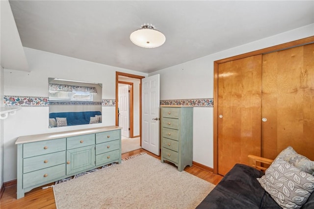 bedroom with light hardwood / wood-style floors and a closet