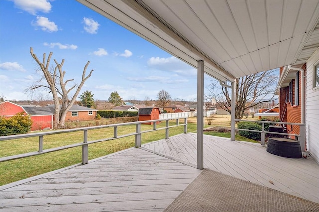 wooden deck featuring a storage shed and a yard