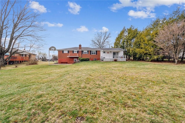 back of house with a lawn and covered porch