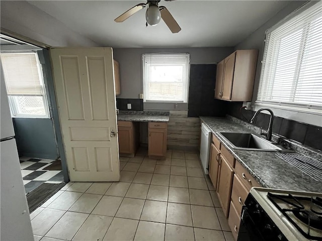 kitchen with sink, range with gas cooktop, light tile patterned floors, white dishwasher, and ceiling fan