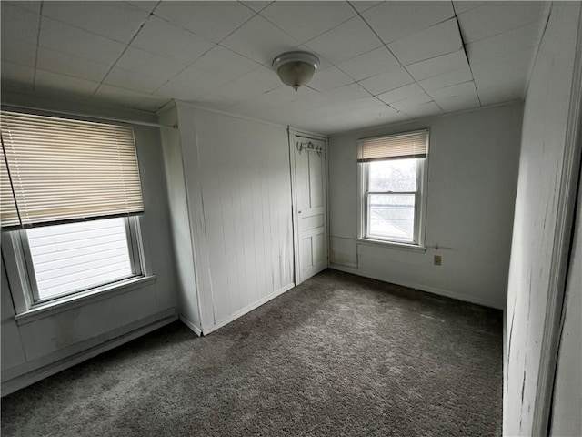 unfurnished room featuring dark carpet