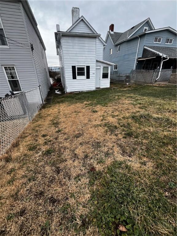 rear view of property featuring a yard