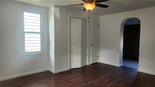 unfurnished bedroom featuring dark hardwood / wood-style flooring, a closet, and ceiling fan