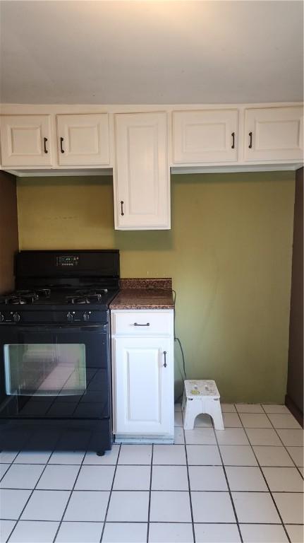 kitchen with white cabinetry, gas stove, and light tile patterned flooring