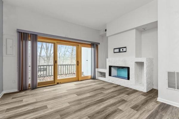 unfurnished living room featuring light hardwood / wood-style flooring and a high end fireplace