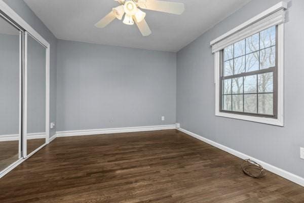 unfurnished bedroom with ceiling fan, dark hardwood / wood-style flooring, and a closet