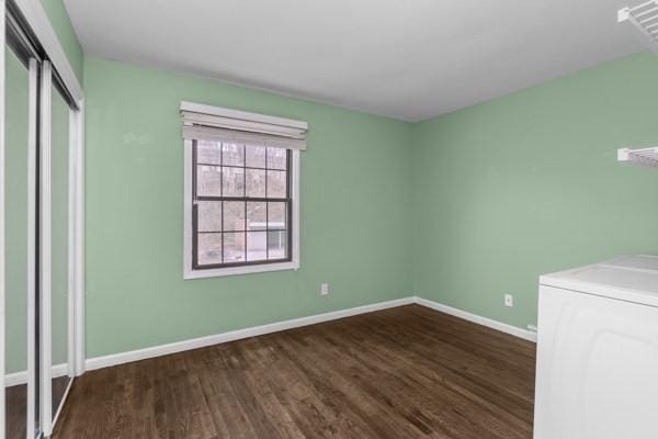 unfurnished bedroom with washing machine and clothes dryer and dark hardwood / wood-style flooring