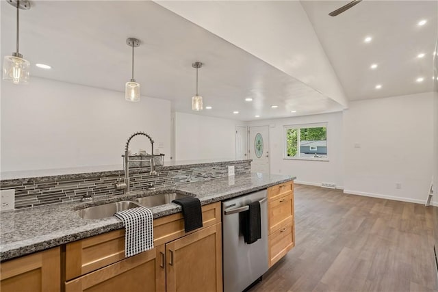 kitchen featuring sink, decorative light fixtures, light stone countertops, and dishwasher