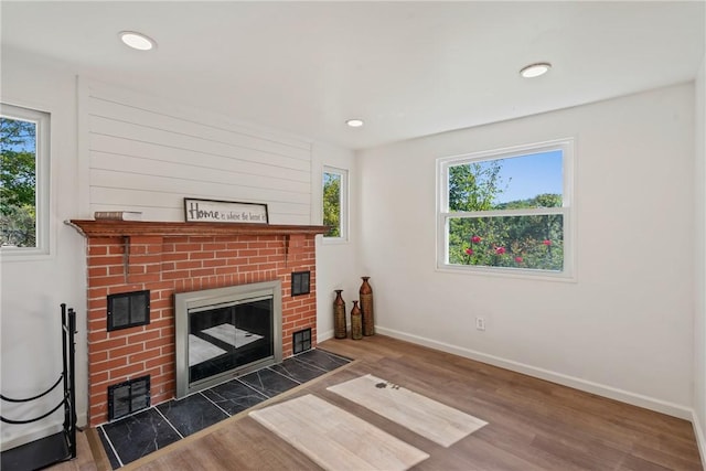 living room featuring a brick fireplace, plenty of natural light, and dark hardwood / wood-style floors