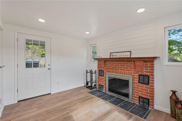 living room featuring hardwood / wood-style flooring and a brick fireplace