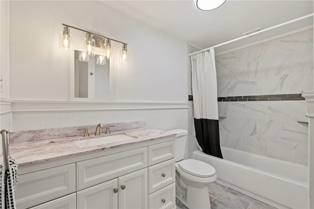 full bathroom with vanity, shower / tub combo with curtain, and toilet