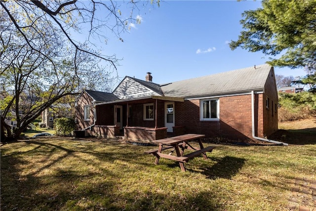 rear view of property with a yard