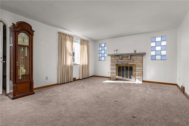 unfurnished living room with a stone fireplace and carpet floors