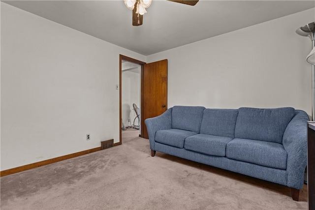 carpeted living room with ceiling fan